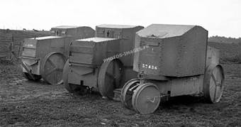 Photo de trois petits v&eacute;hicules blind&eacute;s stationn&eacute;s dans un champ